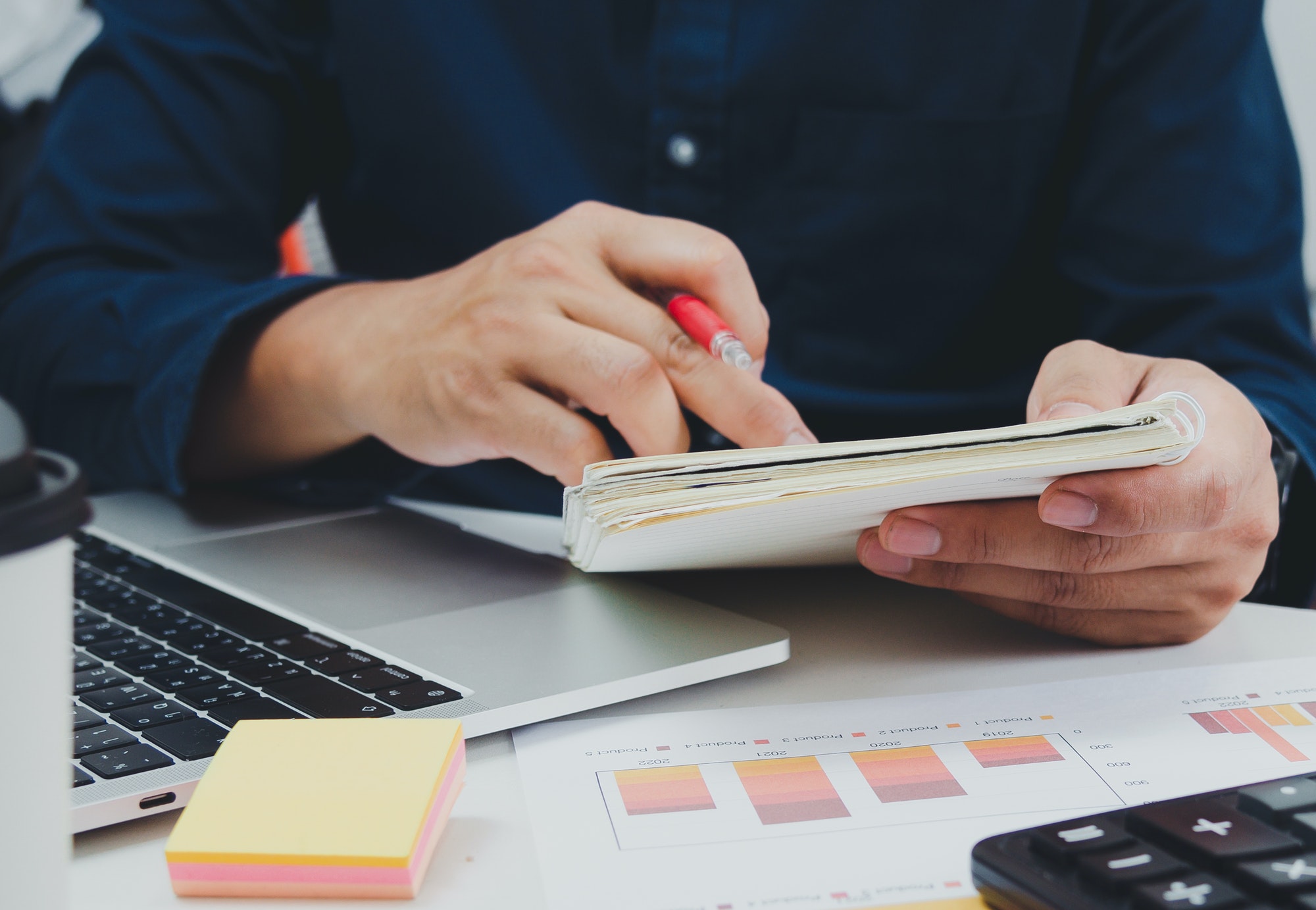 Business man holding pen and book on desk document accounting tax