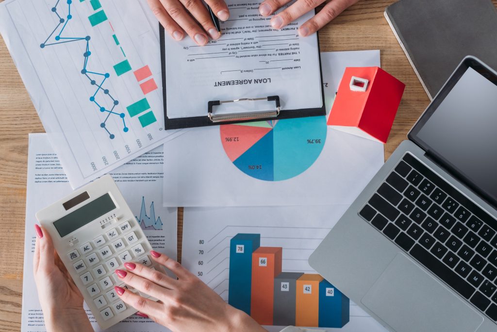 cropped shot of man reading loan agreement and businesswoman using calculator while sitting at